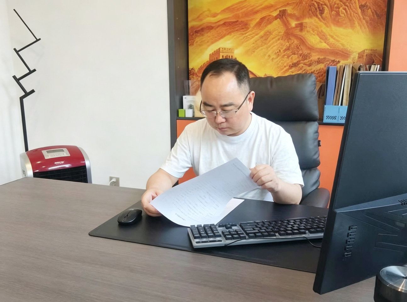孟哥在办公桌前核对资料